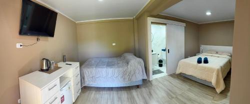 a bedroom with two beds and a television in it at Hotel SMA in Puerto Iguazú