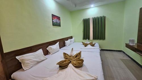 een hotelkamer met twee bedden met bogen erop bij Hotel Sai Pratham in Shirdi