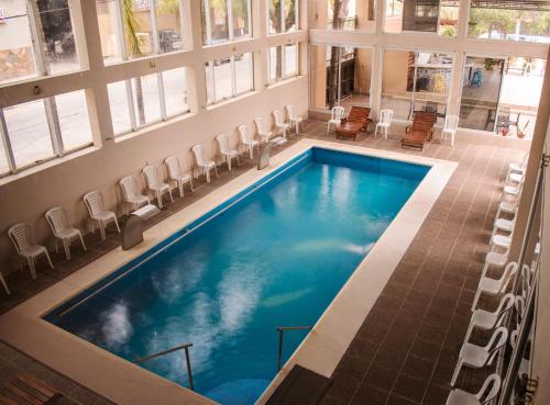 a large swimming pool in a building with windows at City Hotel Termal in Termas de Río Hondo