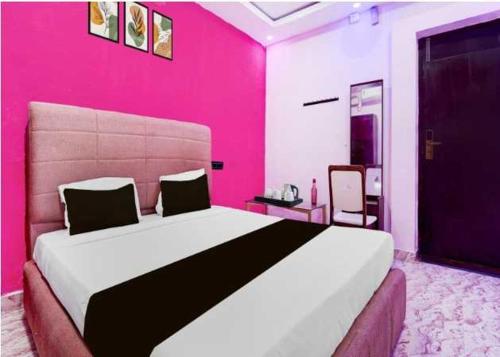 a bedroom with a large bed in a pink room at Collection O Mappedu Chennai Formerly Nitas Business Hotel in Kāndūr