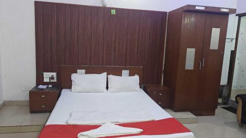 um quarto com uma cama grande com cabeceira de madeira em Hotel O Shakuntala Park Bus Terminus Behala em Behāla