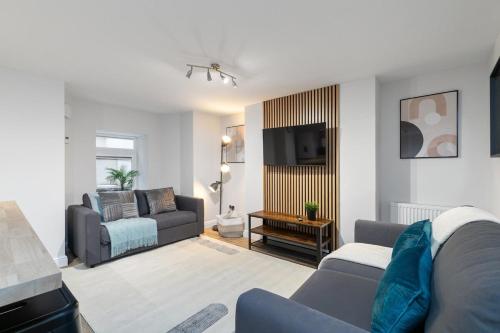 a living room with a couch and a tv at Back Brudenell Mount in Headingley