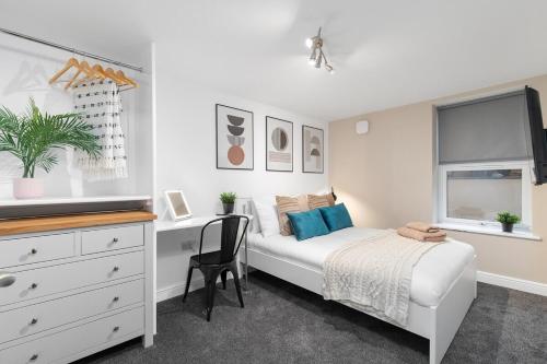 a bedroom with a bed and a desk and a dresser at Back Brudenell Mount in Headingley