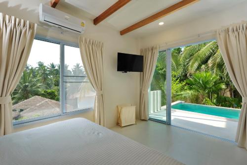 a bedroom with a bed and a view of a pool at Peaceful Villa with Private Pool Garden Views by Sea N' Rent in Haad Chao Phao