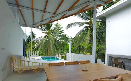 a patio with a table and a swimming pool at Peaceful Villa with Private Pool Garden Views by Sea N' Rent in Haad Chao Phao