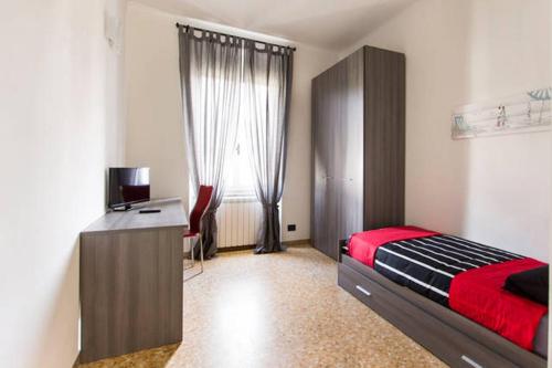1 dormitorio con cama, escritorio y ventana en Casa Vacanze Luli, en La Spezia