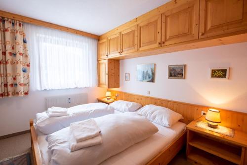 two beds in a bedroom with wooden cabinets at Chalet Alpine Royal A Top 2 in Krimml
