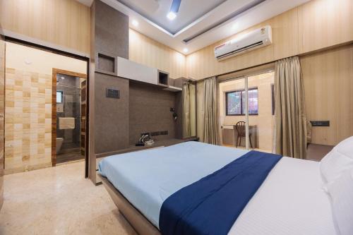 a bedroom with a large bed and a bathroom at Royale Enclave by JadeCapsNr.Manipal Hosp. in Ballygunge