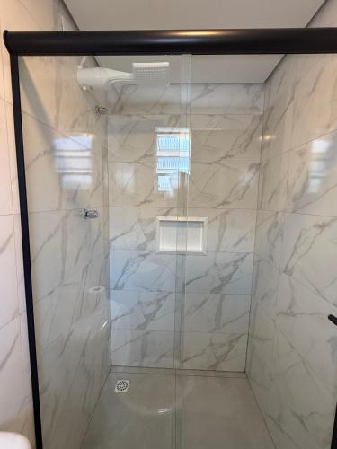 a shower with a glass door in a bathroom at Hotel New Brás in São Paulo