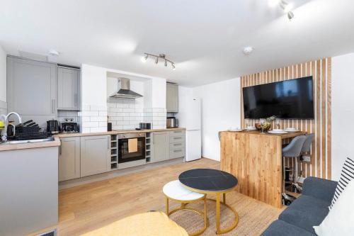 a kitchen and living room with a couch and a table at Popular Two Bed Apt in Leeds City in Headingley