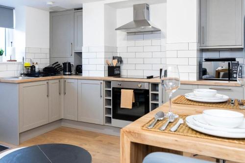 a kitchen with a table with plates and wine glasses at Popular Two Bed Apt in Leeds City in Headingley