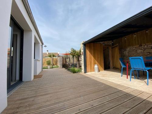 een terras met blauwe stoelen op een huis bij Charming house - Grand Village Plage in Grand-Village-Plage