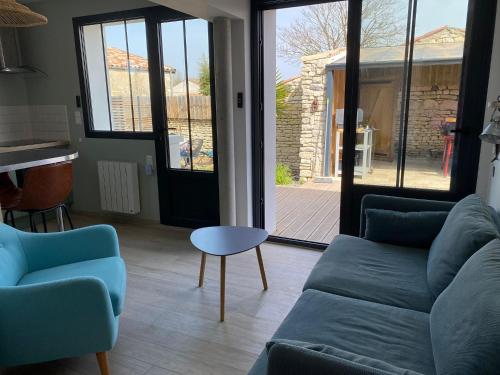 een woonkamer met een bank en een tafel bij Charming house - Grand Village Plage in Grand-Village-Plage