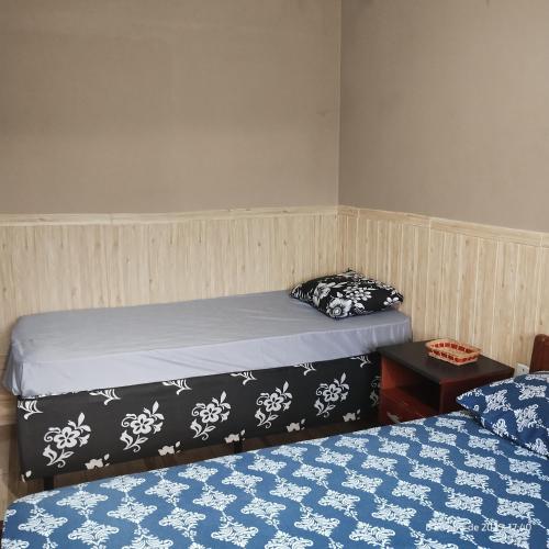 a bedroom with two beds and a table with a pillow at Apartamento Embaúbas in São José