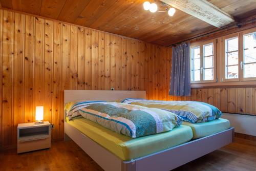 a bedroom with two beds in a wooden wall at Ferienwohnung Schleif in Niederwald