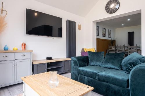 a living room with a blue couch and a table at 4 bedroom bungalow in Kettering - Garden - Parking - WiFi in Kettering