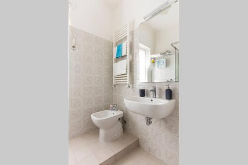 a white bathroom with a sink and a toilet at Casa Vacanze Luli in La Spezia