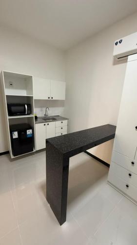 a kitchen with a black bench in a room at Cabanos Prime Hotel e Residencial in Barcarena
