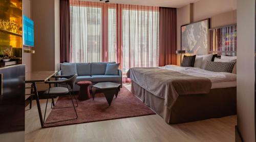 a bedroom with a bed and a desk and a chair at Marski by Scandic in Helsinki