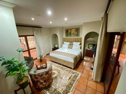 a bedroom with a bed and a living room at Kloofyard Guesthouse in Pretoria