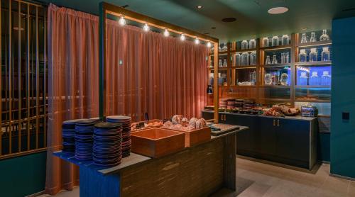 a restaurant with a counter with plates and dishes at Marski by Scandic in Helsinki