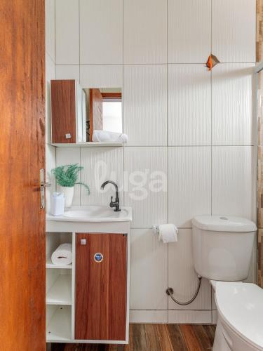 a white bathroom with a sink and a toilet at LUGA: Peaceful Retreat | Lagoon & Imbituba in Imbituba
