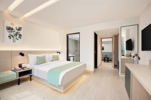 a bedroom with a large bed and a bathroom at Fortune Park Galaxy, Vapi - Member ITC Hotels' Group in Vapi