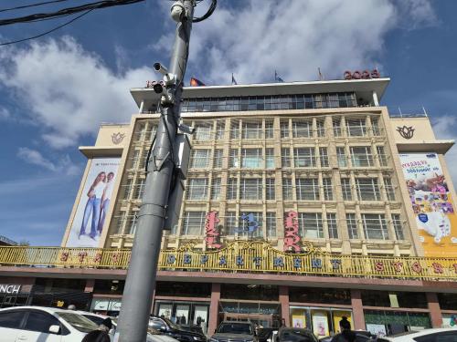 un grande edificio con auto parcheggiate di fronte di Tsese a Ulaanbaatar