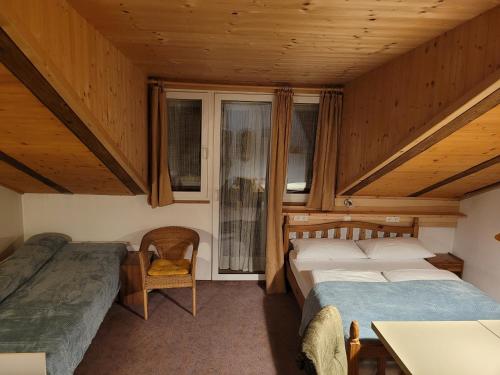 a bedroom with two beds and a table and a chair at Gassermühle - Studio Appartments in Eggen