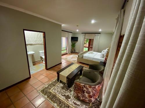 a bedroom with a bed and a living room at Kloofyard Guesthouse in Pretoria