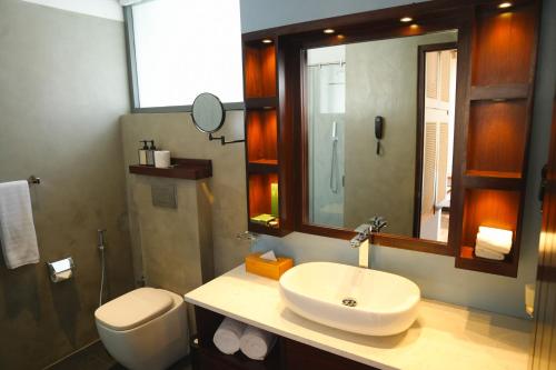 une salle de bain avec un lavabo, des toilettes et un miroir dans l'établissement Montagna Luxury Hotel, à Nuwara Eliya