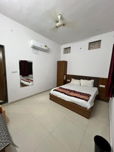 a bedroom with a bed and a ceiling fan at Hotel Shri Ram Palace in Jhālāwār
