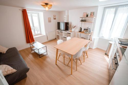 a living room with a table and a couch at Charmant T2 plein centre in Saint-Astier