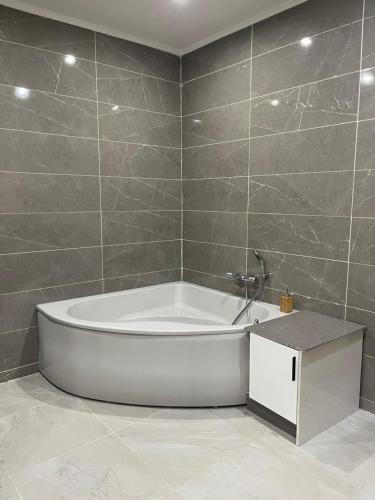 baño con bañera blanca y azulejos en Cozy home North, en Paramaribo