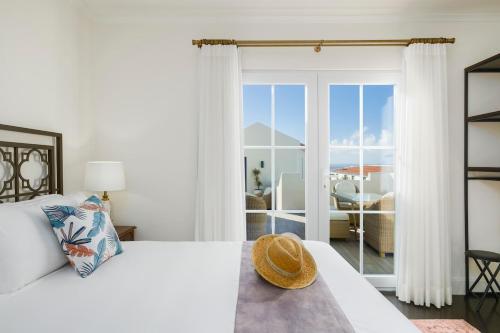 a white bedroom with a bed and a large window at Solar do Sabão - Your Gathering Place in Relva