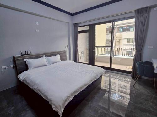 東港鎮にある東港包棟 悠舍民宿の大きなベッドと大きな窓のある寝室