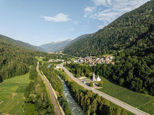 una vista aerea di una città in montagna con un fiume di ALPEDOR Mountain Suites a Commezzadura