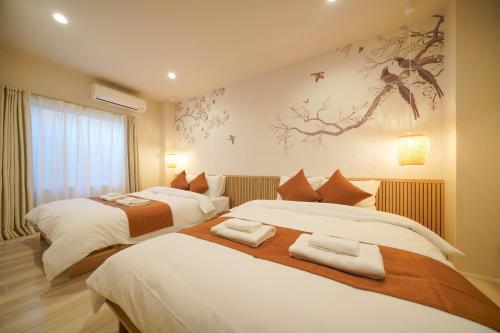 a bedroom with two beds and a painting on the wall at LinksHotel上野 in Tokyo