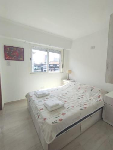 a white bedroom with a large bed with flowers on it at Catalina - Excelente ubicación en pleno centro - 2A in Santa Fe