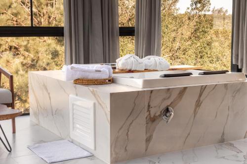 a white counter with towels on it in front of a window at Cabana Morada nas Nuvens in Pinto Bandeira