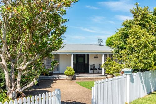 a white fence in front of a white house at Vince's Landing - Stunning Big Private Waterfront Cottage in Erowal Bay