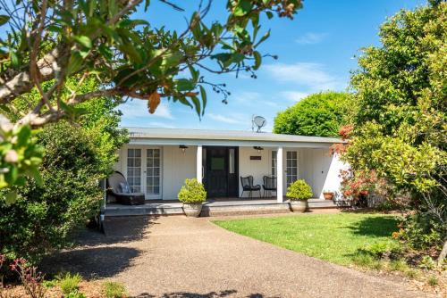 a white house with a garden at Vince's Landing - Stunning Big Private Waterfront Cottage in Erowal Bay