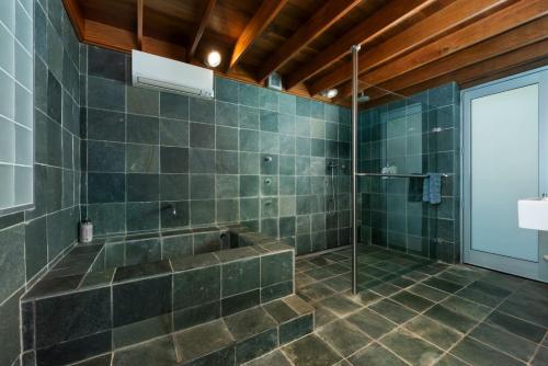 ein großes Bad mit einer Dusche und einer Badewanne in der Unterkunft Stunning Big Private Waterfront Cottage in Erowal Bay