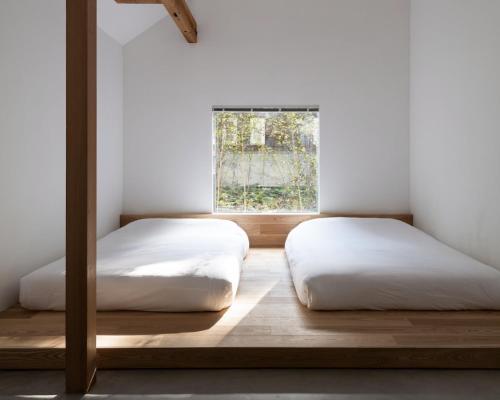 嬬恋村にあるWHITE HUT l ホワイトハットの窓のある部屋にベッドが2つある
