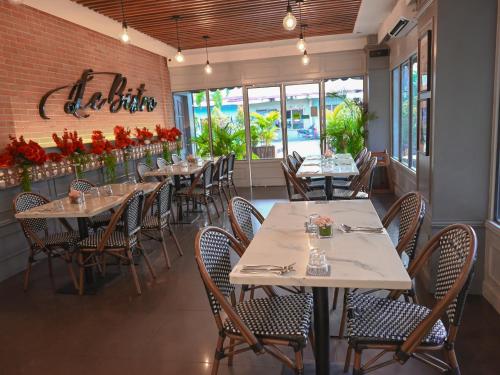 a dining room with tables and chairs and flowers at Hotel Bijoux in Plaridel