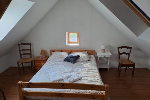 1 Schlafzimmer mit einem Bett mit 2 Stühlen und einem Fenster in der Unterkunft Les Gites de Louisette Le 974 in Ébreuil