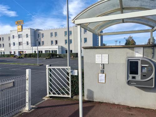 a bus stop with a gate in a parking lot at Premiere Classe Caen Nord - Mémorial in Caen