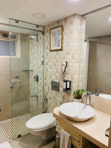 a bathroom with a sink and a toilet and a shower at Fortune Park Galaxy, Vapi - Member ITC Hotels' Group in Vapi