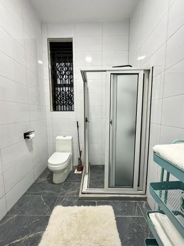 MunyonyoにあるMorganのトイレとガラスのシャワー付きのバスルーム