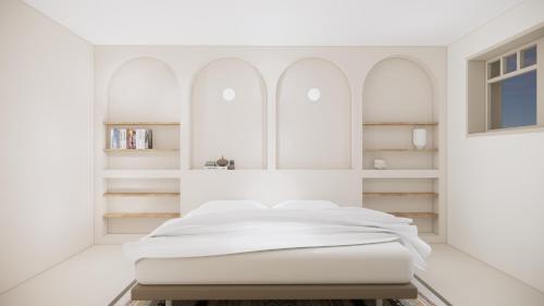 ein weißes Schlafzimmer mit einem weißen Bett und Regalen in der Unterkunft Villa d'architecte avec piscine et plage à pied in La Teste-de-Buch